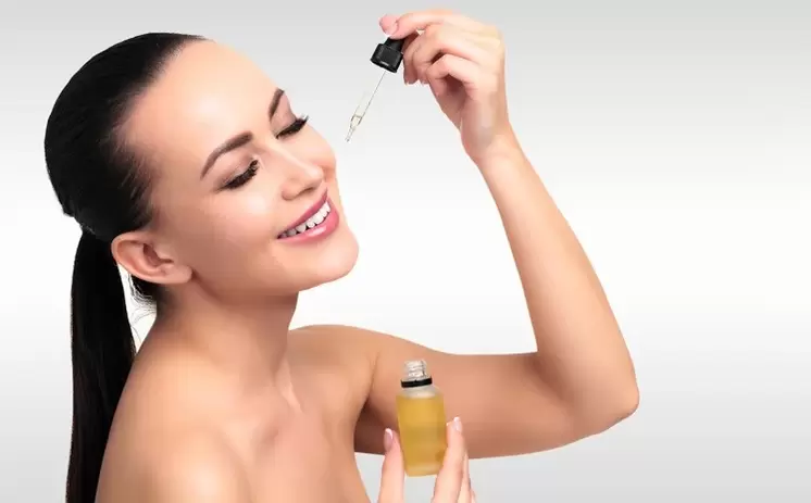 The woman wears a serum on her face